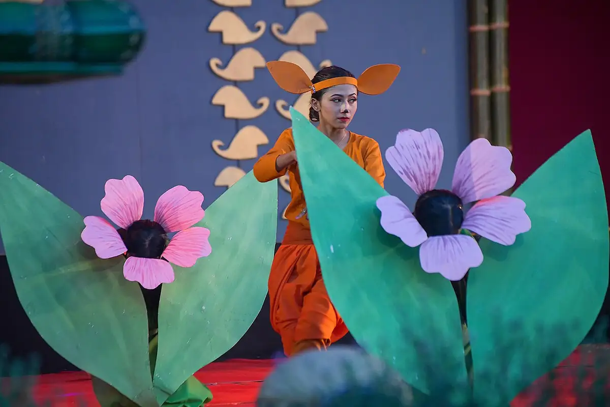 A dancer with large flower props on stage at the Sangai Festival in Manipur